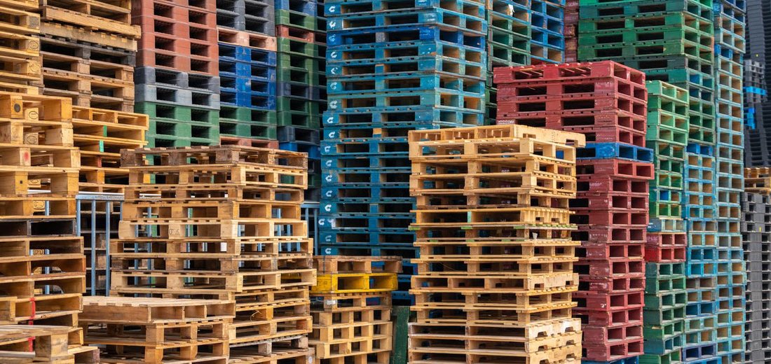 Stacks of colourful wooden pallets in a warehouse